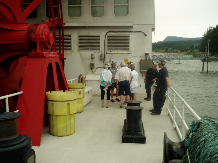 The chief engineer and two of his assistants talk with passengers during the engine room tour